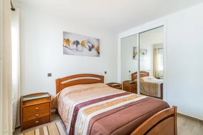 a bedroom with a bed and a mirror at Appartement ALGARDEN Olhos d'Agua in Olhos de Água