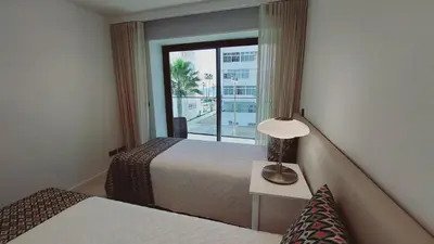 a hotel room with a bed and a window at Apartamento Meerblick in Quarteira