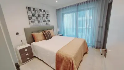 a bedroom with a bed and a large window at Apartamento Meerblick in Quarteira