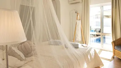 a bedroom with a bed with a mosquito net at Villa O Canto da Parra - Hot Jacuzzi - Swimming Pool - WIFI - BY BEDZY in Galé