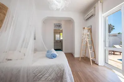 a bedroom with a bed with a white canopy at Villa O Canto da Parra - Hot Jacuzzi - Swimming Pool - WIFI - BY BEDZY in Galé