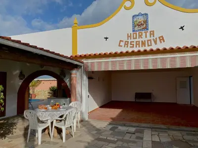 a patio with a table and chairs in front of a building at Palma's Place Casanova Villa #WIFI#HEATEDPOOL#RELAX in Faro