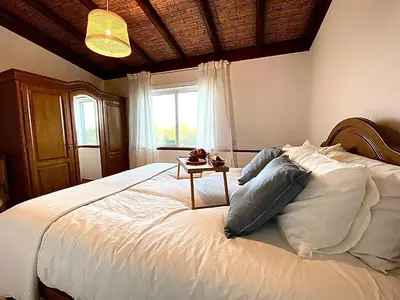 a bedroom with a large bed with a table on it at Palma's Place Casanova Villa #WIFI#HEATEDPOOL#RELAX in Faro