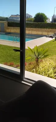 a window with a view of a plant in a yard at Appartement Standing au coeur d'Albufeira in Albufeira