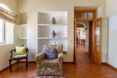 a living room with a chair and a hallway at Monte Velho in Loulé