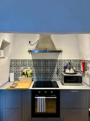 a kitchen with blue cabinets and a stove top oven at Stilvolles Architekten-Cottage mit Pool in Boliqueime