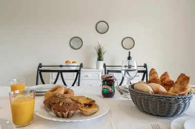 a table with a basket of bread and a basket of orange juice at Villa Lemos by HelloVacations in Albufeira
