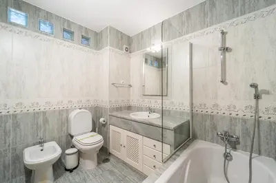 a bathroom with a toilet and a tub and a sink at Villa Lemos by HelloVacations in Albufeira