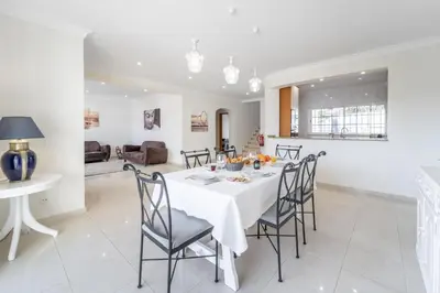 a dining room and living room with a table and chairs at Villa Lemos by HelloVacations in Albufeira