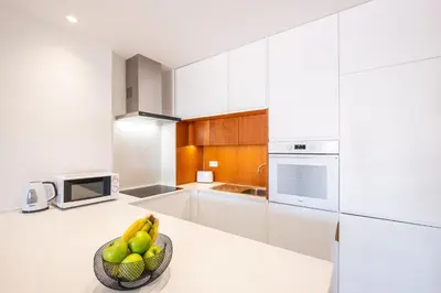 a kitchen with white cabinets and a microwave at #079 T1 Vale Mangude by Home Holidays in Albufeira