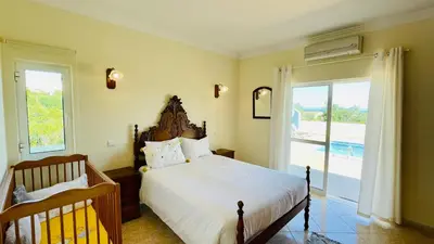 a bedroom with a large bed and a sliding glass door at Lara Lima by Check-in Portugal in Albufeira