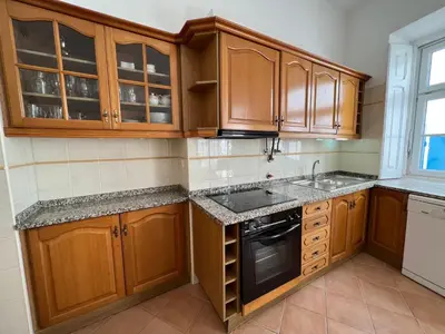 a kitchen with wooden cabinets and a sink at Santa Clara Old Town in Albufeira