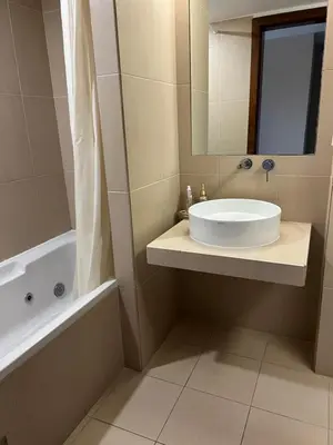 a bathroom with a sink and a tub and a mirror at Salgados, Vila das Lagoas in Albufeira