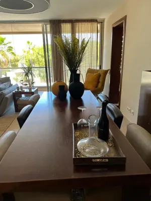 a living room with a large wooden table with glasses on it at Salgados, Vila das Lagoas in Albufeira