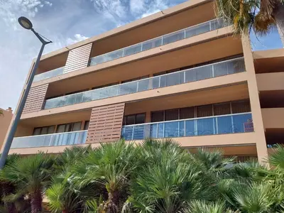 a building with palm trees in front of it at Salgados, Vila das Lagoas in Albufeira