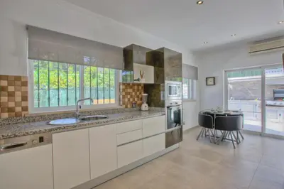 a large kitchen with a sink and a stove at Casa da Horta in Almancil