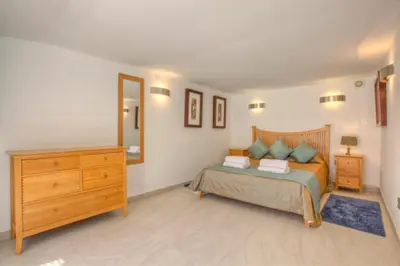 a bedroom with a bed with a dresser and a mirror at Casa da Horta in Almancil
