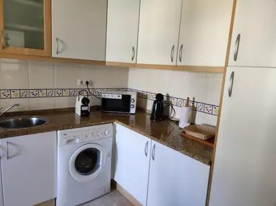 a kitchen with a washing machine and a sink at Vila Atlântida - Vilamoura-Quarteira Holiday Home - Beach at 250 mts in Quarteira