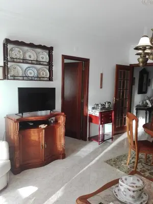 a living room with a television and a table at Vila Atlântida - Vilamoura-Quarteira Holiday Home - Beach at 250 mts in Quarteira