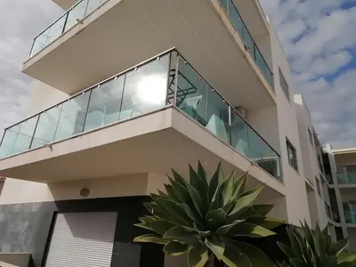 a building with a balcony with plants in front of it at Modern apartment with sunny south facing terrace in Albufeira