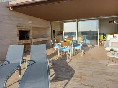 a patio with a table and chairs and a fireplace at Prestige & Nature Apartment in Laguna Village in Quarteira