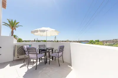 a patio with a table and chairs and an umbrella at Amazing 2-Bedroom Appartment with big terrace! in Albufeira