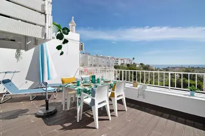 a patio with a table and chairs on a balcony at Ocean View Apartment Hakuna Matata in Albufeira