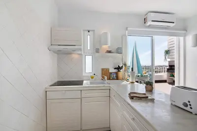 a white kitchen with a sink and a window at Ocean View Apartment Hakuna Matata in Albufeira