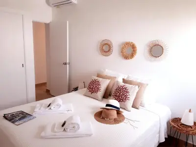 a white bed with towels and hats on it at Beach Apartment Terrace in Vilamoura