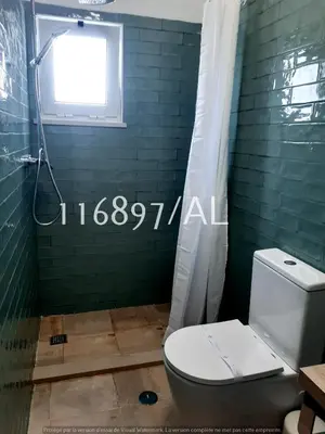 a bathroom with a toilet and a green wall at Beach Apartment Terrace in Vilamoura