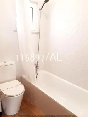 a white bathroom with a toilet and a bath tub at Beach Apartment Terrace in Vilamoura