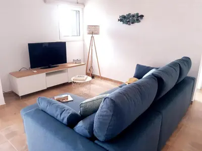 a blue couch in a living room with a tv at Beach Apartment Terrace in Vilamoura