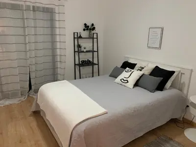 a bedroom with a bed with black and white pillows at OmniaX Apartment in Faro