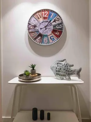a clock hanging on a wall above a white shelf at Downtown Albufeira 3-Bedroom Luxury Apartment in Albufeira