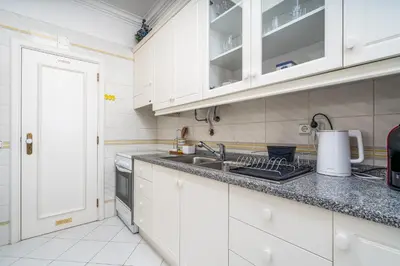 a kitchen with white cabinets and a sink at Vilamoura City Centre Flat in Vilamoura