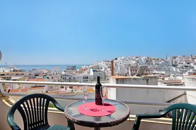a bottle of wine sitting on a table on a balcony at Paradis Bleu in Albufeira