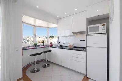 a kitchen with white cabinets and a microwave at Paradis Bleu in Albufeira