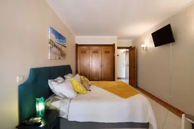 a bedroom with a large bed with yellow pillows at Paradis Bleu in Albufeira