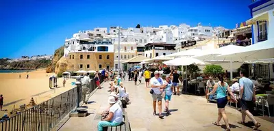 a beach with rocks and people in the water at Home Sweet Home in Albufeira