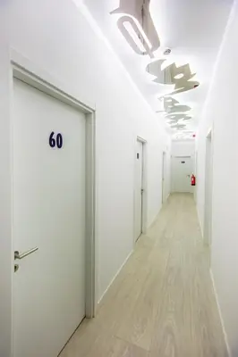 an empty corridor of an office with white doors and wood floors at Musical Hostel in Albufeira