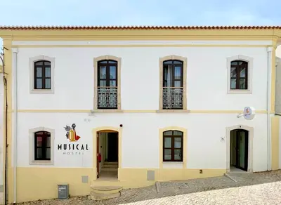a white building with a sign that reads mulilla at Musical Hostel in Albufeira