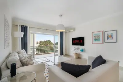 a living room with two white couches and a glass table at WHome Family Holidays w/ S-Pool, AC, Elevator & Garage in Quarteira