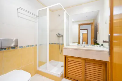 a bathroom with a shower and a sink and a toilet at WHome Family Holidays w/ S-Pool, AC, Elevator & Garage in Quarteira