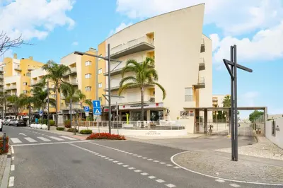 an empty street with a cross in front of a building at WHome Family Holidays w/ S-Pool, AC, Elevator & Garage in Quarteira