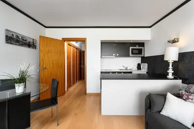 a kitchen and living room with a table and a couch at Apartamento Portugal in Quarteira