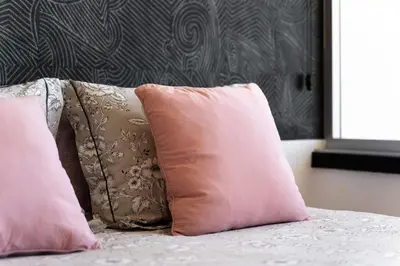 two pink pillows sitting on top of a bed at Apartamento Portugal in Quarteira