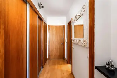 a hallway with wooden doors and a wooden floor at Apartamento Portugal in Quarteira