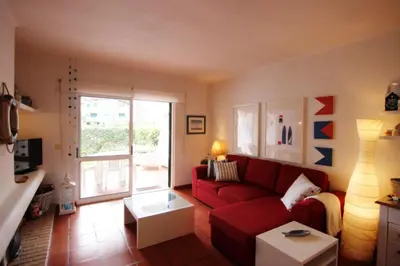 a living room with a red couch and a window at Golf Apartment - Solar do Golfe Condominium in Vilamoura