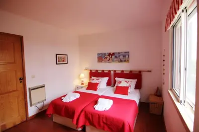 a bedroom with a red and white bed with two pillows at Golf Apartment - Solar do Golfe Condominium in Vilamoura
