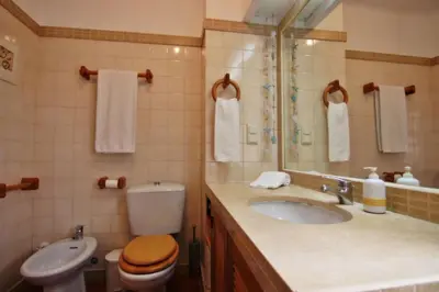 a bathroom with a sink and a toilet and a mirror at Golf Apartment - Solar do Golfe Condominium in Vilamoura